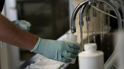 Getty Images File image of a hand holding a vessel under a tap while water comes out
