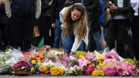AFP A woman lays flowers at a pedestrian crossing on the south side of London Bridge, close to Borough Market in London.