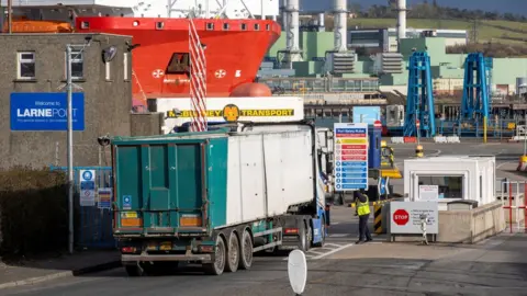 Liam McBurney/PA Wire Security staff at Larne Port speak with a lorry driver (archive photo from March 2021)