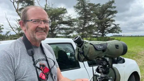 Andrew Turner/BBC Dave Horton birdwatching near Hickling Broad