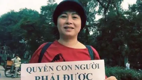 Human Rights Watch Vietnamese rights campaigner Nguyen Thuy Hanh holding a placard in English and Vietnamese saying "Human rights must be respected"