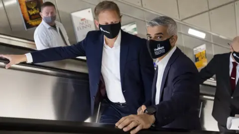 PA Media Mayor of London Sadiq Khan and Transport Secretary Grant Shapps travel on an escalator