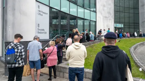 Getty Images People queue outside the Newport HM Passport Office on 24 May 2022 in Newport, Wales.