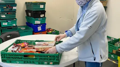 BBC General view of food being put in a pallet at a food bank in Birmingham