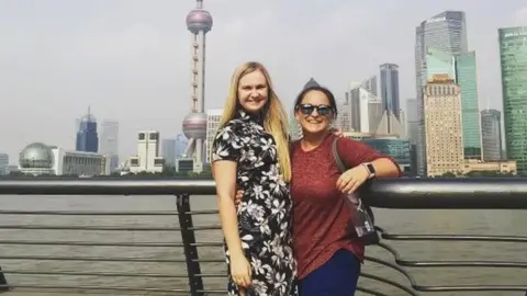 Keri & Kate Davies Two women pose for the camera in front of Shanghai's Oriental Pearl Tower