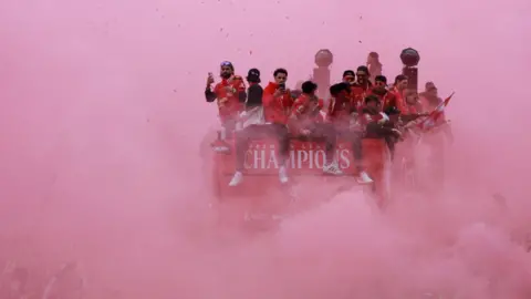 The Liverpool parade bus entirely surrounded with red smoke on 26 May 2025