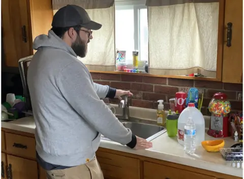 Mr Ratner is using bottled water to clean dishes because he doesn't trust the tap