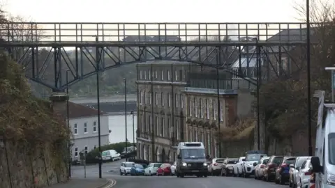 BBC A van drives beneath the metal footbridge in North Shields