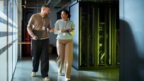 two people walking through a server room