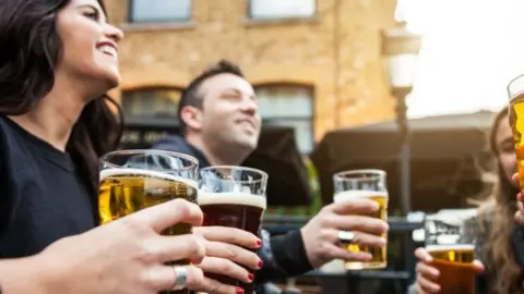 Getty Images People sharing a drink outdoors