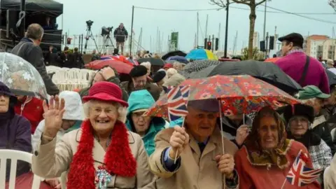 Crowds gathered under umbrellas