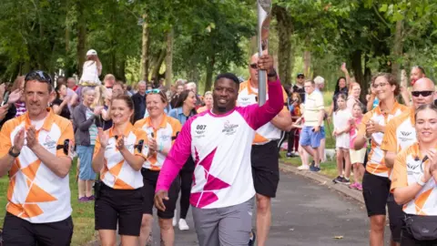 Getty Images Ricardo D'Alva takes part in the Birmingham 2022 Queen's Baton Relay as it visits Arrow Valley Country Park