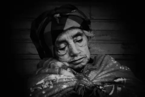 James Rodriguez Juliana Tum Sicá, 78, watches as a forensic anthropologist takes her DNA sample. Xexuxcap, Nebaj, Quiche, Guatemala. February 10, 2021.