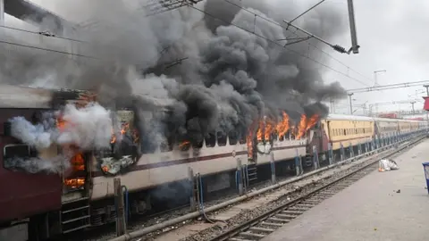 Getty Images Protester set ablaze Farakka Express train during a protest against the Agnipath army recruitment scheme at Danapur Railway Station on June 17, 2022 in Patna, India.