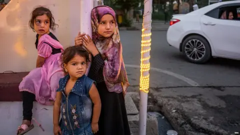 Girls waiting outside an ice cream restaurant in Kabul