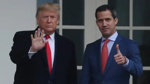 EPA Guaidó gives a thumbs up to the camera while Trump holds his hand out in front of him