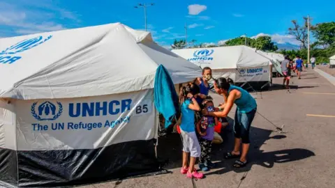 Getty Images Venezuelan migrants exit a tent set up at the Tienditas International Bridge in Cucuta, Colombia, on the border with Venezuela, set up for Venezuelans who have been waiting at the Simon Bolivar International Bridge