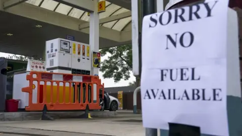 PA Media A petrol station with a sign saying no fuel available