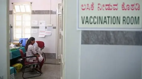 EPA An Indian woman receives a shot of COVID-19 vaccine during the vaccination drive at Dasappa government hospital in Bangalore, India, 25 February 2021.