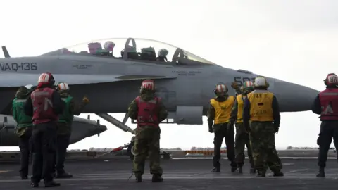 AFP US Navy crew members stand by an EA-18G Growler electronic warfare aircraft on the deck of the Nimitz-class aircraft carrier USS Carl Vinson during a South Korea-US joint military exercise in seas east of the Korean Peninsula on 14 March 2017