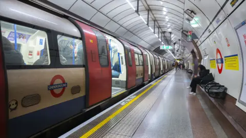 Getty Images People wait for an underground ahead of the strike of underground workers, 1 April 2024