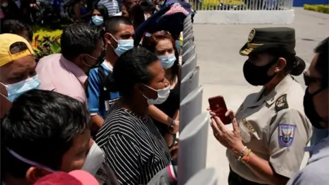 Reuters Family members of inmates speak with a police officer while waiting outside a morgue for identification of the dead after a riot broke out at the Penitenciaria del Litoral prison in Guayaquil, Ecuador September 30, 2021