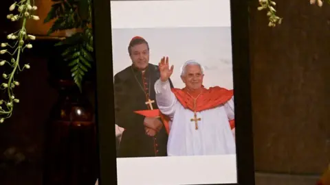 Getty Images A framed photograph showing Cardinal George Pell with Pope Benedict XVI is seen on display at St Patrick's Cathedral