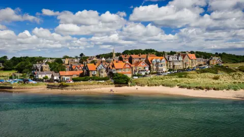 Getty Images Aerial shot of sea, beach and houses at Alnmouth