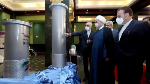 Reuters Iranian President Hassan Rouhani (2nd left) is shown nuclear technology in Tehran on 10 April 2021