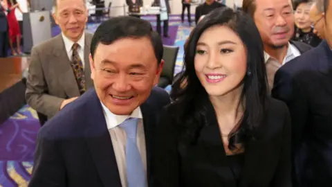 Getty Images Former Thai prime ministers Thaksin Shinawatra (L) and his sister Yingluck Shinawatra (R)