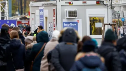 Reuters People wait in front of a vaccination point