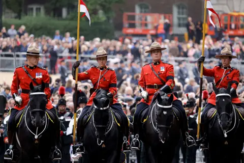 AFP Members of the Royal Canadian Mounted Police, take part in the Procession following the coffin of Queen Elizabeth II, on September 19, 2022, to make its final journey to Windsor Castle after the State Funeral Service of Britain's Queen Elizabeth II