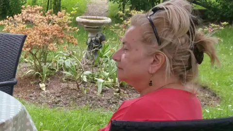 GIROLAMI FAMILY Ms Girolami in a garden wearing jewellery