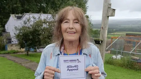 Sharon Edmunds Founder Annabelle Walter stands outside holding a flyer for the fundraising appeal