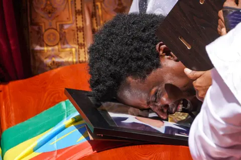 Getty Images A mourner cries on the coffin of his loved one during a memorial service for the Ethiopian passengers and crew who perished in the Ethiopian Airways ET302 crash