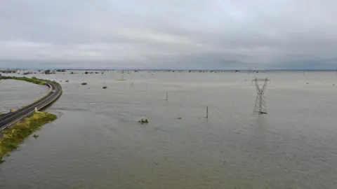 Reuters A car drives by a flooded area after Cyclone Idai in Beira, Mozambique March 20, 2019