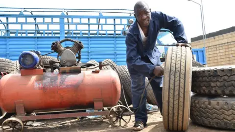 Viola Kosome Lucas Obwar repairs tyres in Kondele, Kisumu County