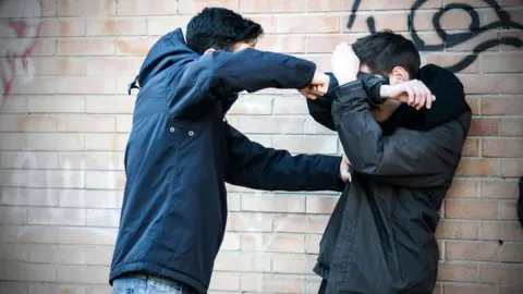Getty Images Staged scene of two teen youths fighting