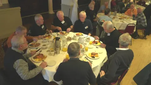 BBC Club members sitting around a table eating breakfast