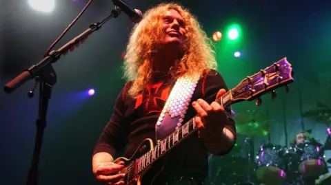 John Sykes playing a Les Paul guitar with Thin Lizzy