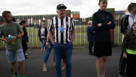 Getty Images An elderly man in Ashington wears an old Newcastle United shirt and cap