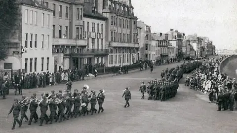 BBC German troops marching along Guernsey's seafront during the occupation during World War Two