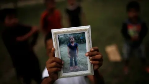 Reuters Jakelin Caal's brother Abdel holds a picture of her sister outside their home in San Antonio Secortez. Photo: 22 December 2018