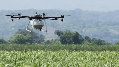 Hylio Crop-spraying drone over crop field