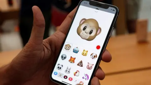 Reuters A man holds up new iPhone with "animoji" feature