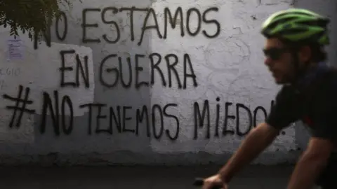 Un graffiti de Reuters en una pared en Santiago dice: "No estamos en guerra #no tenemos miedo"