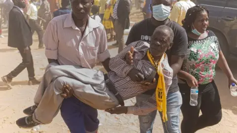 AFP CCC supporter being carried after breaking a leg during a stampede and alleged attack provoked by Zanu-PF supporters