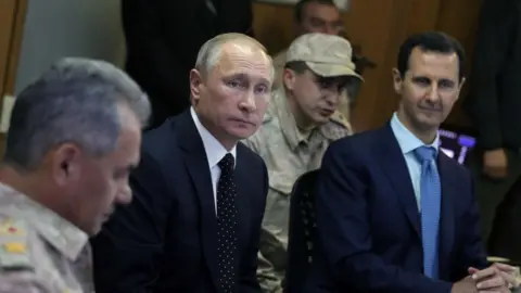 TASS/Getty Putin with Bashar al-Assad in 2017