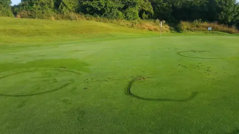 Hollingbury Golf Course A golf course with tyre tracks.