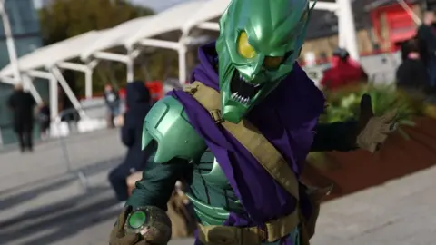 Isabel Infantes/Getty Images A person dressed as the Green Goblin holds a scary pose outside the event